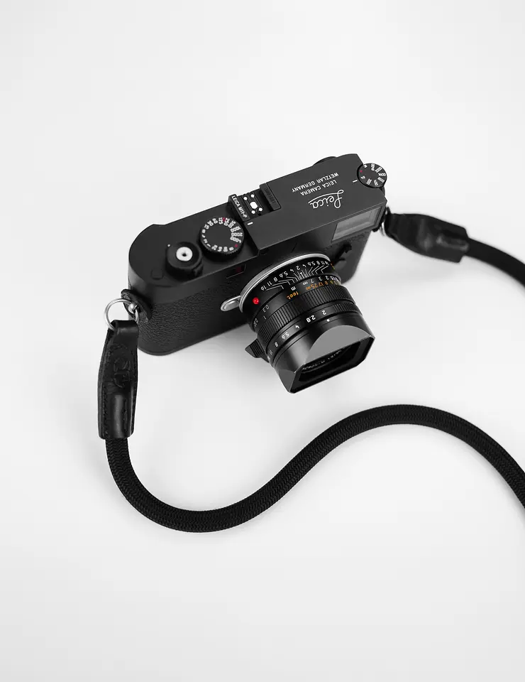 Leica M11-P mit APO-Summicron-M 1:2/35 ASPH. und Seilgurt, von oben auf weißem Grund